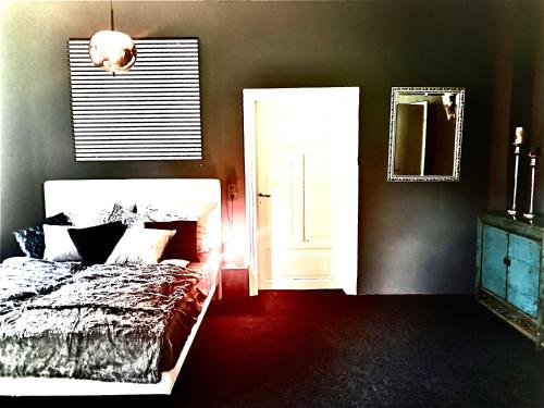 a bedroom with a bed and a door and a mirror at Adlershof in Hemmersheim