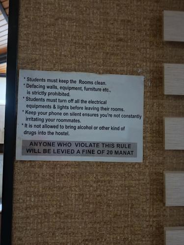 a sign on the side of a brick wall at Adnan Company Hostel in Baku