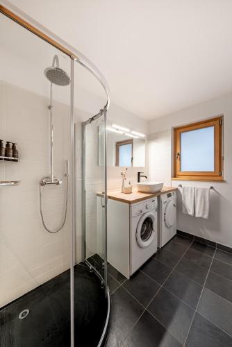 a bathroom with a sink and a washing machine at Ride Inn Verbier - B&B - private small twin room, shared bathrooms in Verbier