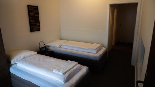 two twin beds in a room with a hallway at A7 Apartments in Komárno