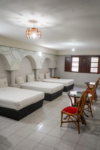 a hotel room with two beds and a table and chairs at OYO Hotel Santander Veracruz Centro Historico in Veracruz