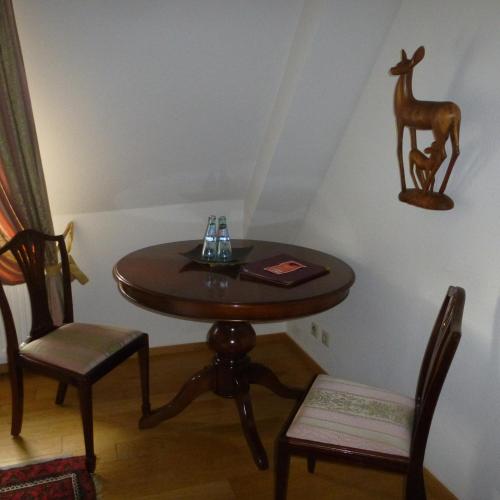 a table with a chair and a table with a deer on the wall at Schloss Hotel Wallhausen in Wallhausen