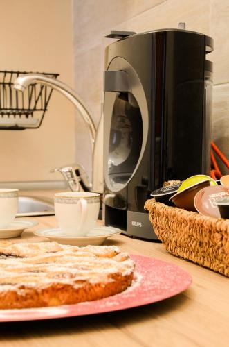 a kitchen counter with a microwave and a cake on a table at Casa Scola Loano in Loano