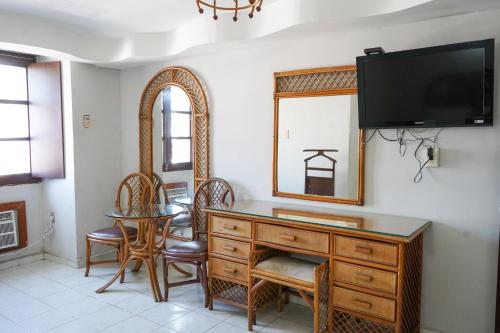 a room with a dresser and a mirror and a table at OYO Hotel Santander Veracruz Centro Historico in Veracruz