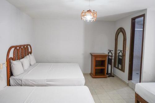 a bedroom with a bed and a table and a mirror at OYO Hotel Santander Veracruz Centro Historico in Veracruz