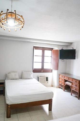 a bedroom with a bed and a desk and a chandelier at OYO Hotel Santander Veracruz Centro Historico in Veracruz