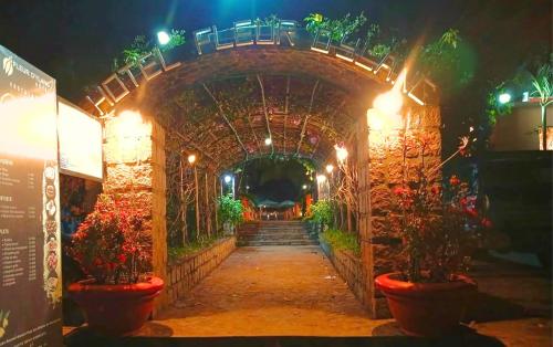 an entrance to a tunnel with flowers and lights at Fleurs d'Ylang in Nosy Be