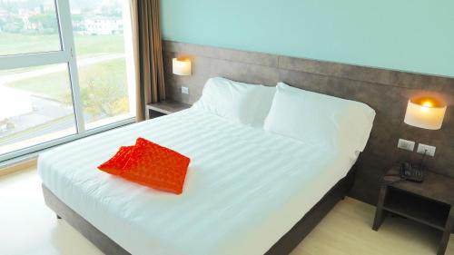 a bedroom with a bed with a red pillow on it at Blu Arena Hotel in Montecchio