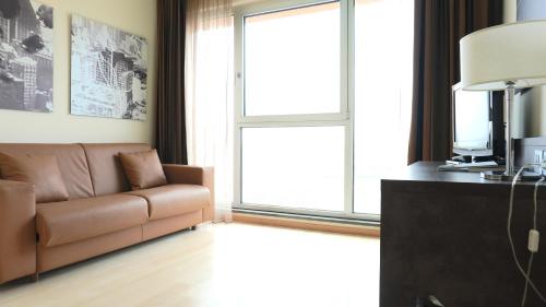 a living room with a couch and a large window at Blu Arena Hotel in Montecchio