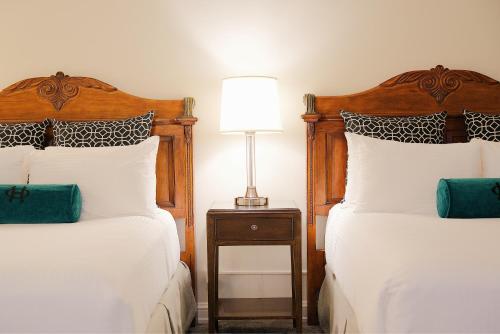 a bedroom with two beds and a lamp on a night stand at The Oxford Hotel in Denver