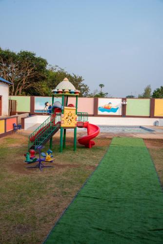 a playground with a slide on a green lawn at Hapuwani Village Lodge in Mulanje