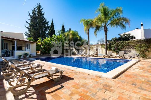 a swimming pool with lounge chairs next to a house at Quinta do Vale Formoso in Armação de Pêra