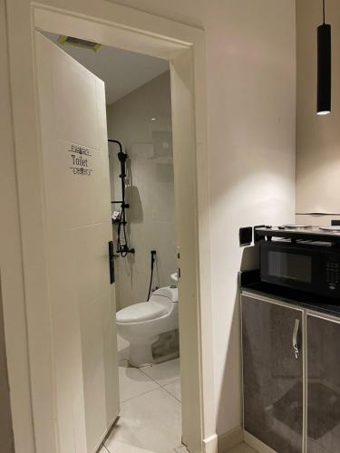 ein kleines Badezimmer mit Toilette und Mikrowelle in der Unterkunft استديو فندقي ومودرن بمدخل ذاتي بجانب البوليڤارد in Riad
