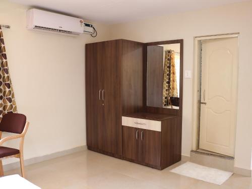 a brown cabinet in a room with a mirror at Kinara Stay in Kumta