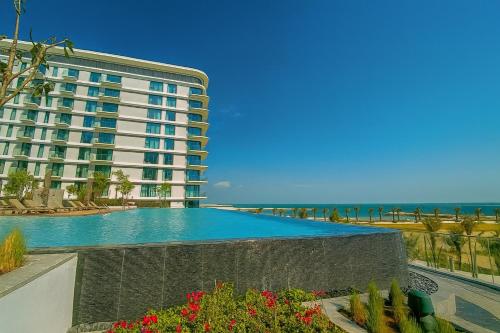 a large hotel with a swimming pool next to the ocean at Address Residence Marassi Vista-studio in Amwaj Island