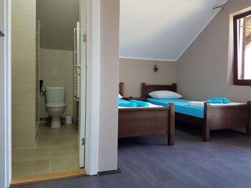 a bedroom with two beds and a shower and a toilet at Apartmani Simić Valjevo in Valjevo