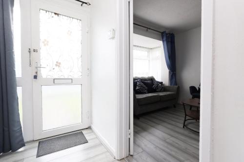 an open door to a living room with a couch at Lovely 3-Bed in Scenic Aberdare! in Aberdare