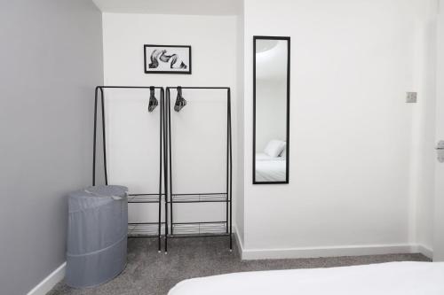 a white room with a mirror and a bed at Lovely 3-Bed in Scenic Aberdare! in Aberdare