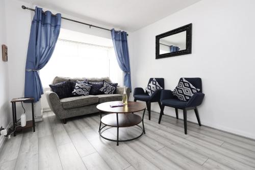 a living room with a couch and chairs and a table at Lovely 3-Bed in Scenic Aberdare! in Aberdare