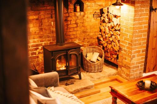 a brick fireplace in a living room with a wood stove at Ye Olde Cottage in Crawley