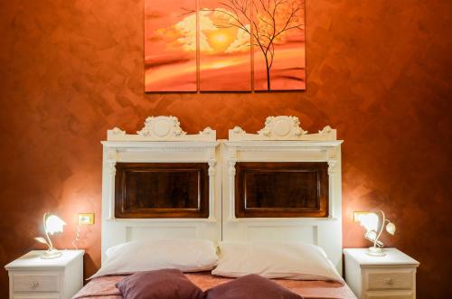 a bedroom with a white bed with two windows at Casa Scola Loano in Loano