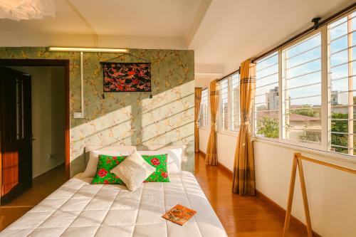 a bedroom with a bed in a room with windows at Flower Homestay-Grand opening-VIP Homestay Local-Indochic-4Bedrooms in Hanoi