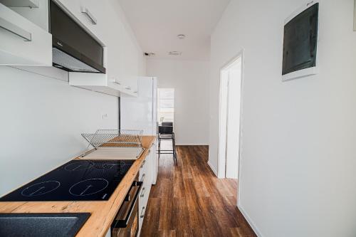 a kitchen with white cabinets and a wooden counter top at Comfort Rooms Obrežje by Highway, Free Covered Parking in Jesenice na Dolenjskem