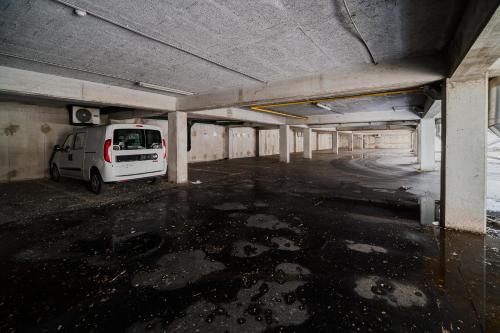 a white van parked in an empty parking garage at Comfort Rooms Obrežje by Highway, Free Covered Parking in Jesenice na Dolenjskem