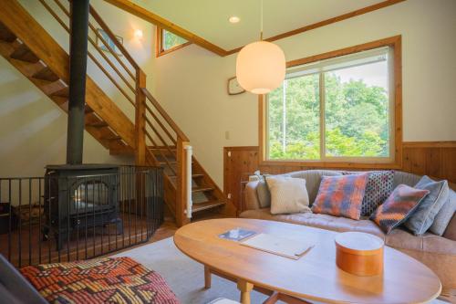 a living room with a couch and a table at LAMP Nojiriko The Sauna by the Lake in Shinano