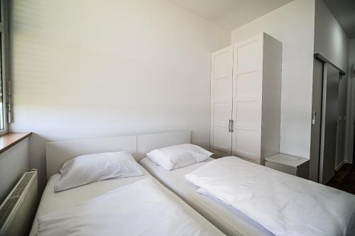 a bedroom with two beds with white sheets at Comfort Rooms Obrežje by Highway, Free Covered Parking in Jesenice na Dolenjskem
