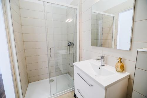 a white bathroom with a shower and a sink at Comfort Rooms Obrežje by Highway, Free Covered Parking in Jesenice na Dolenjskem