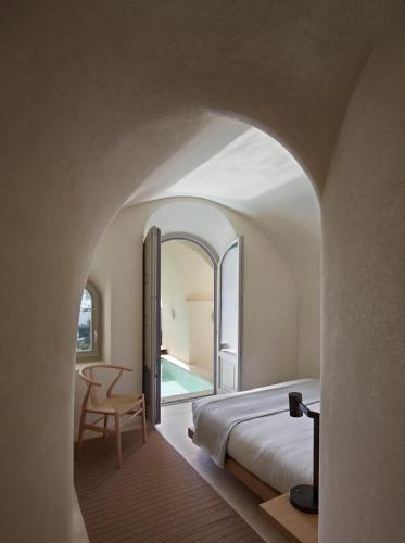 a bedroom with a bed and a table and a chair at Villa Bordeaux in Fira