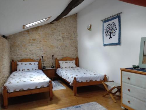a bedroom with two twin beds and a dresser at B&B Franglaise in Romagne