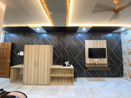 a room with wooden cabinets and a tv on a wall at Hotel Ganga Pearl in Rishīkesh