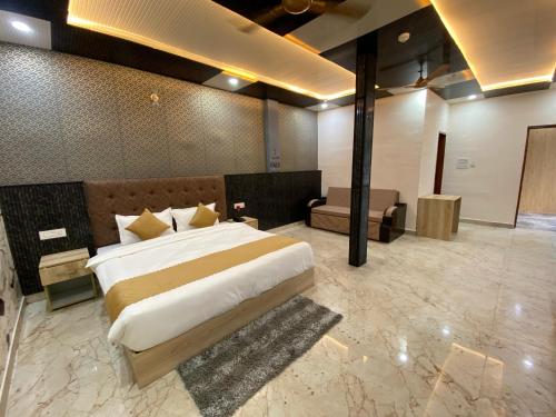 a large bedroom with a large bed and a couch at Hotel Ganga Pearl in Rishīkesh