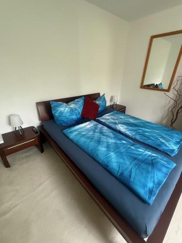 ein Bett mit blauen Laken und Kissen in einem Schlafzimmer in der Unterkunft Welliebeach Große Ferienwohnung in Hameln