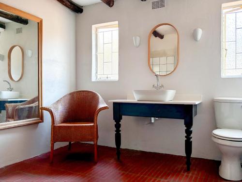a bathroom with a sink and a toilet and a mirror at Bateleur Nature Reserve in Modimolle
