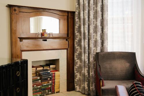 a room with a fireplace with a mirror and a chair at The Oxford Hotel in Denver