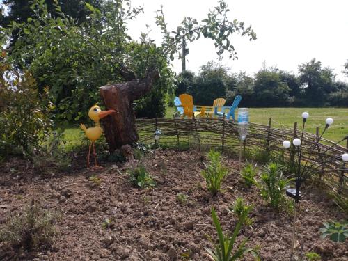 a garden with a toy duck in a fence at B&B Franglaise in Romagne