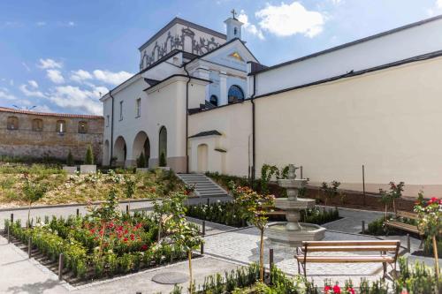 a large white church with a courtyard with flowers at Domus Maria in Vilnius