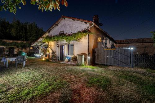 a house with a fence and a yard at night at B&B Franglaise in Romagne