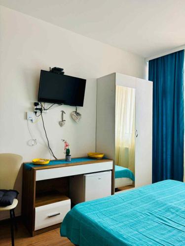 a bedroom with a desk with a tv on the wall at tribu apart hotel in Bakuriani