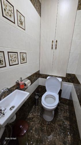 a bathroom with a white toilet and a sink at Уютная светлая квартира для двоих in Hrazdan