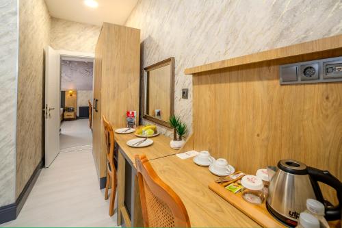 a kitchen with a wooden table with a pot on it at Bulton Hotel Airport in Arnavutköy