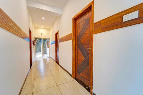 a hallway with a wooden door and a tile floor at FabHotel Raja Residency in Alāndurai