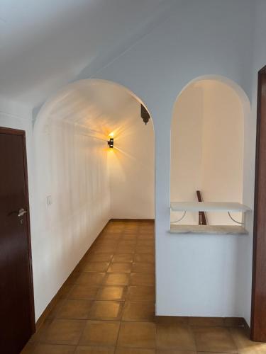 an empty hallway with a white wall and a shelf at Casa de Sintra in Sintra