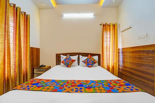a bedroom with a bed with a colorful comforter at FabHotel Raja Residency in Alāndurai