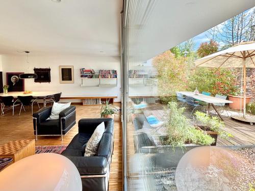 a living room with a couch and a table at Snug Stays 7 - Design House in Starnberg, Terrace, Lake, Munich south in Starnberg