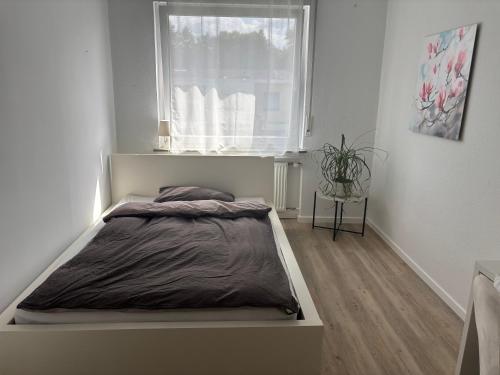 a bed in a white room with a window at Privatzimmer im Reihenhaus nähe Flughafen Hannover Langenhagen in Hannover