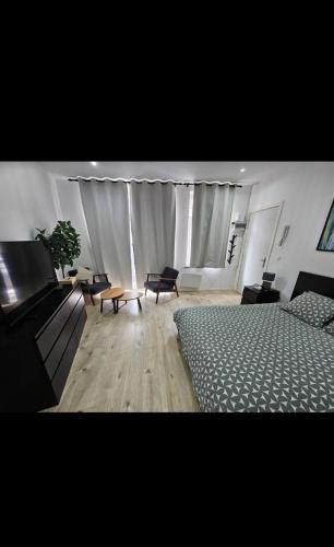 a bedroom with a bed and a couch and a table at Studio cozy et charmant in Brussels
